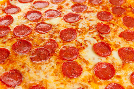 Background from delicious classic italian Pizza Pepperoni with sausages and cheese mozzarellaの写真素材