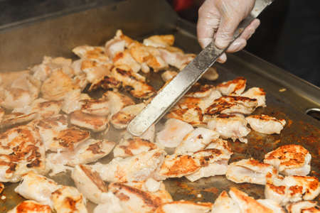 Hands of man take cooking of chicken meat on restaurant kitchenの写真素材