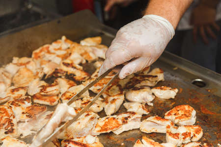 Hands of man take cooking of chicken meat on restaurant kitchenの写真素材