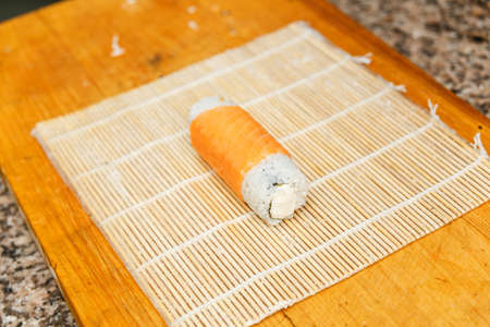 Preparing, sushi ready for cutting on bamboo mat.の写真素材