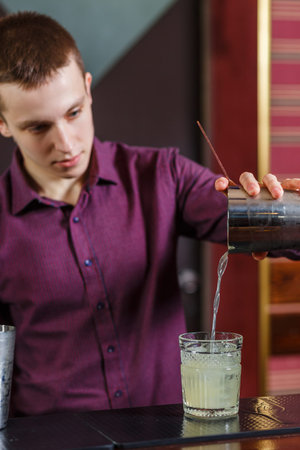 The bartender making cocktail in a nightclub barの写真素材