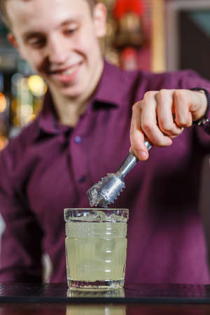 The bartender making cocktail in a nightclub barの写真素材