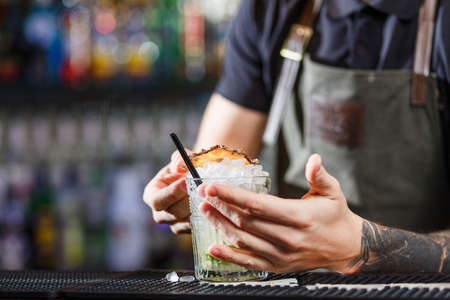 The bartender making cocktail Mojito in a nightclub barの写真素材