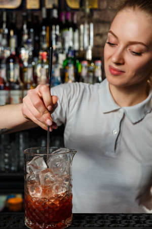 Woman bartender making an alcohol cocktail at the barの写真素材