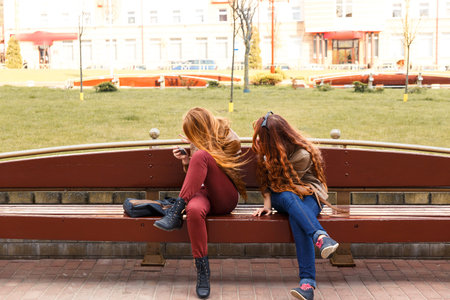 Two girls hide their faces from the photographerの写真素材