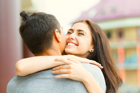 Young couple in love, kissing on the street. Selective focus.の写真素材