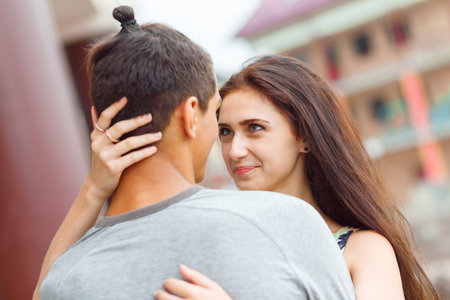 Young couple in love, kissing on the street. Selective focus.
