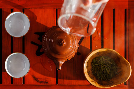The tea ceremony. The woman rinses the teapot before brewing the tea