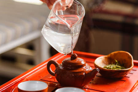 The tea ceremony. The woman rinses the teapot before brewing the teaの写真素材