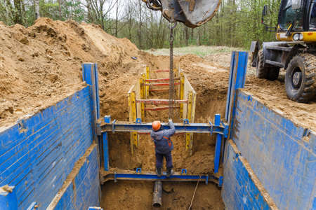 Installation of metal supports to protect the walls of the trench. The lining protects the walls from collapsing and save the workers.の写真素材
