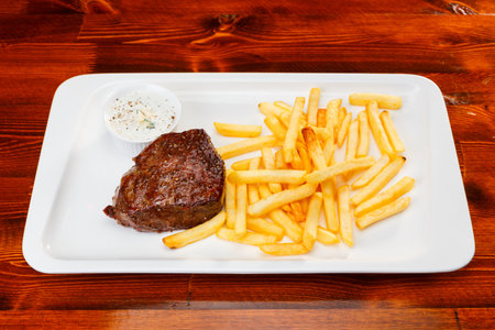 Rustic grilled beefsteak with french fries and garlic sauceの写真素材