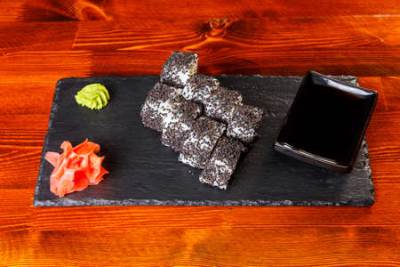 Sushi rolls with shrimps on a black stone plate.の写真素材
