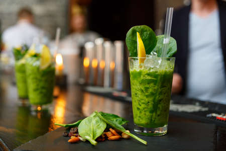 mint spinach cocktail in glass on a bar counterの写真素材