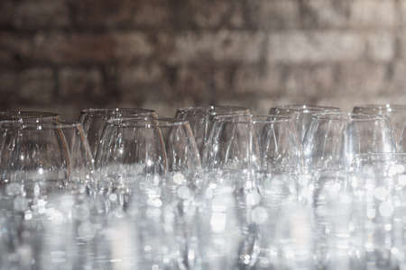 Lots of wine glasses on a brick wall backgroundの写真素材