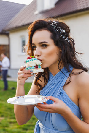 cute bridesmaid eats wedding cake on the wedding ceremonyの写真素材