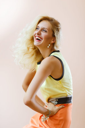 Crazy laughing blonde model posing on pink background