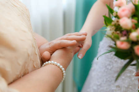 Mom keeps her daughter by the hand on the wedding day. Emotional concept.の写真素材