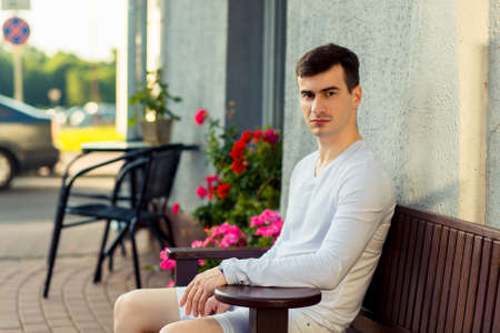 Young handsome man sitting in a street cafeの写真素材