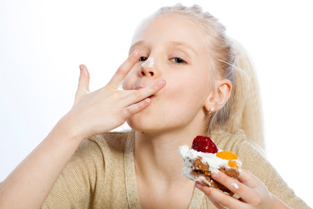 Girl eats a cake on white background.の写真素材