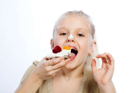 Girl eats a cake on white background.の写真素材