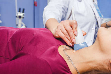 Young Woman Doing Neck Ultrasound Examination At Hospitalの写真素材