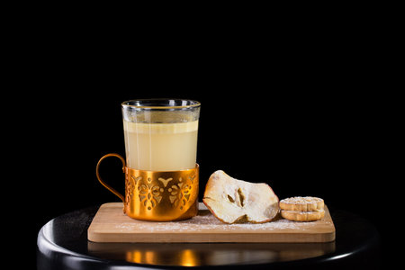 Hot apple cider served with dried apple and cookie isolated on black backgroundの写真素材