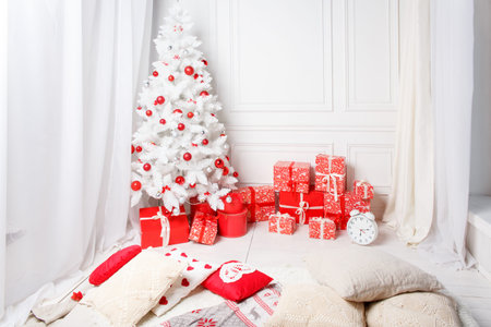 Christmas tree with presents underneath in white living roomの写真素材