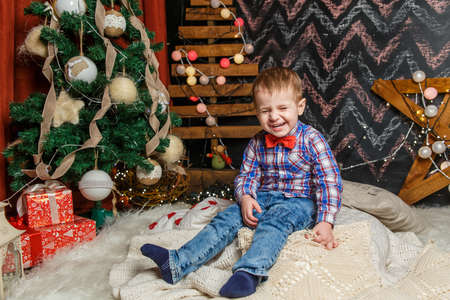 Small boy posing in a Christmas photo session. Studio shooting before the holidaysの写真素材
