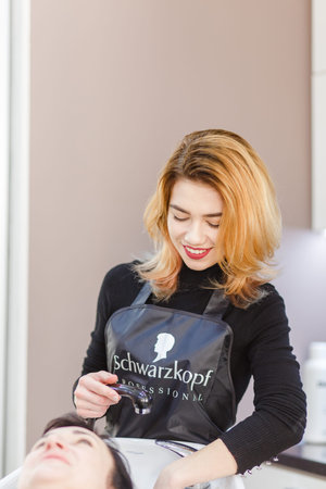 Grodno, Belarus - December 13, 2017: Working day inside the hair salon Art Lok, hairdresser washing...