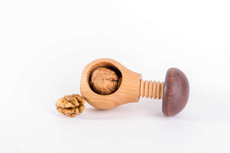 Whole walnuts and wooden screw nutcracker isolated on white background. We like walnuts. Advertising on walnuts.の写真素材