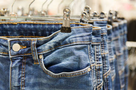 Set of blue jeans hanging on hangers in shopの写真素材