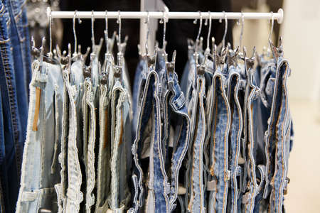 Set of blue jeans hanging on hangers in shopの写真素材