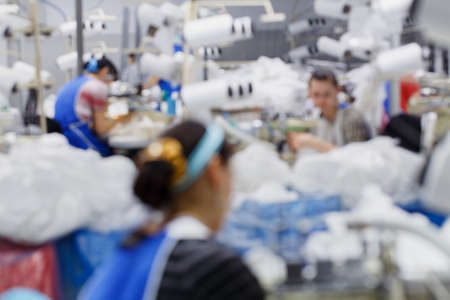 Blurred background with women are engaged in tailoring of tights in a factoryの写真素材