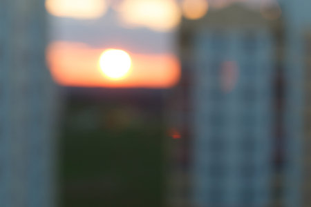 Blurred photo of sunset among the high-rise buildings in the city.