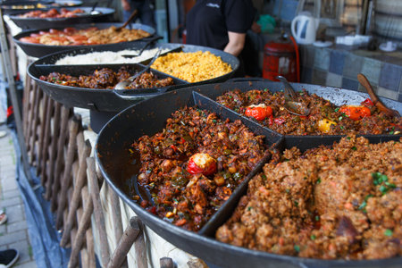 Process of cooking european traditional meat stew. Big plate of fried meat with vegetables. Chef cooking on the street during the holiday of the city Druskininkai, Lithuania.の写真素材