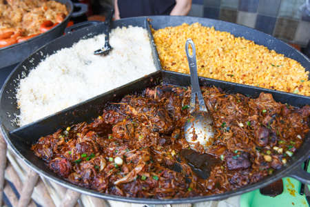 Process of cooking european traditional food. Big plate of fried meat and garnish. Chef cooking on the street during the holiday of the city Druskininkai, Lithuania.の写真素材