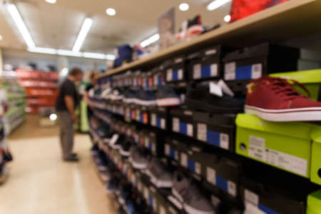 Natural bokeh of  Shoe Store. The buyer chooses sports shoes for purchase.の写真素材
