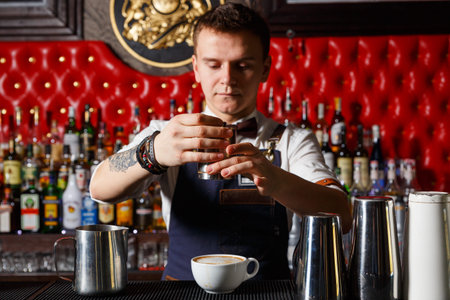Grodno, Belarus - May 01, 2017: Barista decorates the cappuccino in the London bar