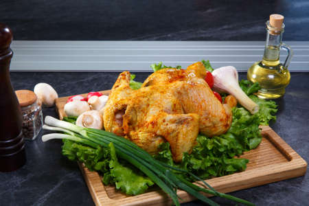 Beautifully served roasted chicken garnished with fresh tomatoesの写真素材