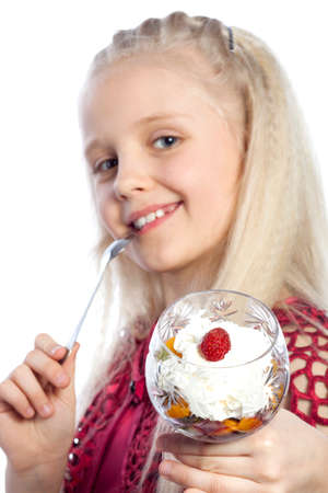 Beautiful blonde girl eating dessert on white backgroundの写真素材