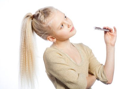 Beautiful girl eating chocolate on white background.の写真素材