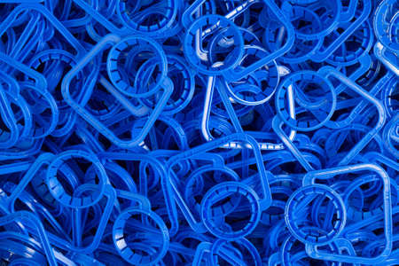 Background of new blue plastic handles for easy carrying of plastic liquid containers.の写真素材