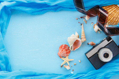 Top view composition - Blank paper photo frames with starfish, shells and items on wooden table....