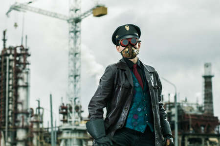 Young man with hammer weared in steampunk style working on railway near by factoryの写真素材