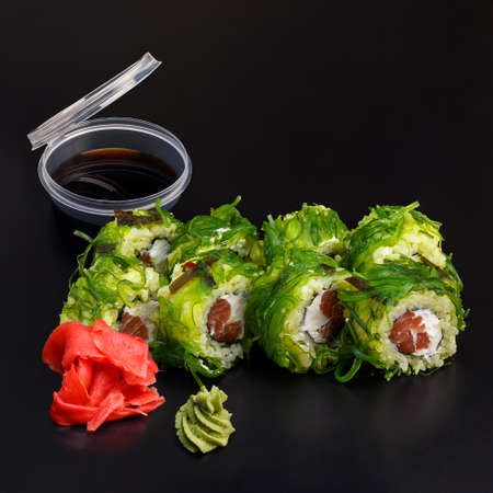 Traditional delicious fresh Chuka syake sushi roll set on a black background with reflection. Sushi roll with rice, cream cheese, nori, salmon. Sushi menu. Japanese kitchen.の写真素材