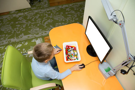Caucasian boy with his friends learning to use a computer at the school of digital technology