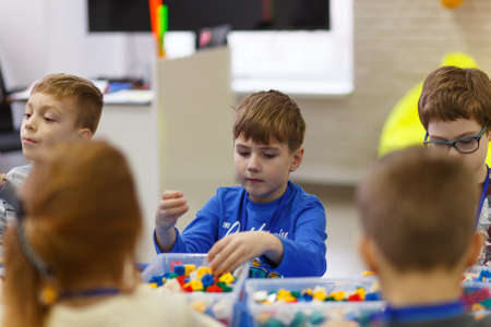 Grodno, Belarus - January 13, 2019: Children collect various objects from plastic parts of the constructor at the school of digital technologies Foresight. Their work is controlled by the teacher.のeditorial素材
