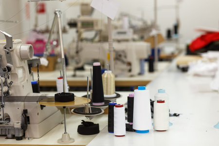 Professional sewing machine with thread in workshop. Equipment for edging, hemming or seaming...