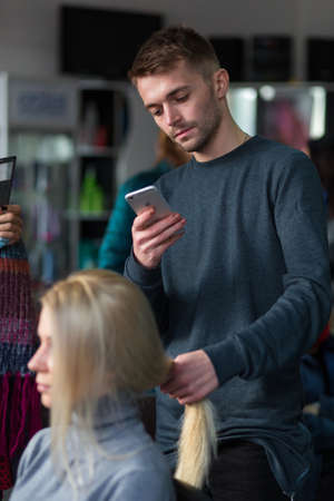 Grodno, Belarus - October 20, 2016: Keune brand technologist Artem Raychuk dyes the hair of a model on advertising workshop with the participation in the beauty salon Kolibri.のeditorial素材