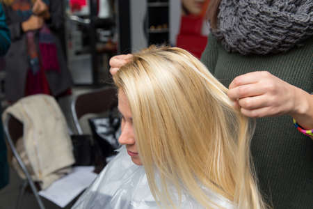 Grodno, Belarus - October 20, 2016: Participants of the seminar dye the hair of a model on advertising workshop of Keune brand in the beauty salon Kolibri.のeditorial素材